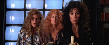 Movie still from “The Witches of Eastwick” (1987), directed by George Miller – A group of women standing next to each other in front of a window; Close Up shot, Low angle
