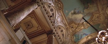 Movie still from “The Witches of Eastwick” (1987), directed by George Miller – The ceiling of a building has a painting on it's wall; Extreme Wide shot, Low angle