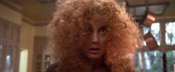 Movie still from “The Witches of Eastwick” (1987), directed by George Miller – A person with long curly red hair; Close Up shot, Low angle