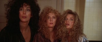 Movie still from “The Witches of Eastwick” (1987), directed by George Miller – A group of women standing next to each other in a room; Close Up shot, Low angle