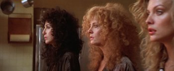 Movie still from “The Witches of Eastwick” (1987), directed by George Miller – Two women with very long , curly hair looking into the distance; Close Up shot, Low angle