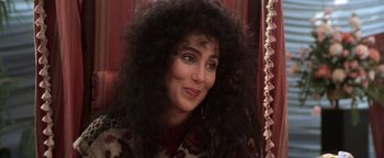 Movie still from “The Witches of Eastwick” (1987), directed by George Miller – A person wearing a wig; Close Up shot, Over the shoulder angle