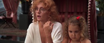 Movie still from “The Witches of Eastwick” (1987), directed by George Miller – A woman and a girl sitting next to each other; Close Up shot, Over the shoulder angle