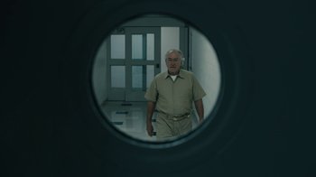 Movie still from “The Wizard of Lies” (2017), directed by Barry Levinson – An older man standing in front of a mirror; Medium shot, Low angle