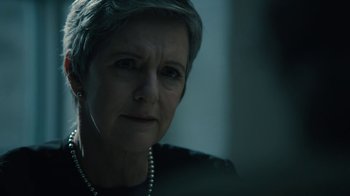 Movie still from “The Wizard of Lies” (2017), directed by Barry Levinson – An older woman with short hair wearing a necklace; Close Up shot, Over the shoulder angle