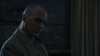 Movie still from “The Wizard of Lies” (2017), directed by Barry Levinson – A man with a bald head is standing in a dark room; Close Up shot, Low angle