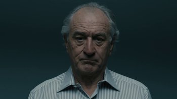 Movie still from “The Wizard of Lies” (2017), directed by Barry Levinson – An older man with a gray beard and a striped shirt; Close Up shot, Low angle
