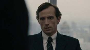 Movie still from “The Wizard of Lies” (2017), directed by Barry Levinson – A person wearing a suit and tie; Close Up shot, Over the shoulder angle