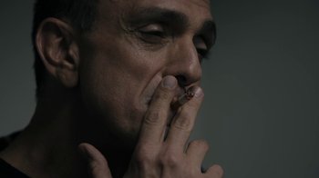 Movie still from “The Wizard of Lies” (2017), directed by Barry Levinson – A person smoking a cigarette; Close Up shot, Low angle