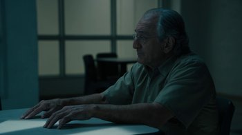 Movie still from “The Wizard of Lies” (2017), directed by Barry Levinson – An older man sitting in front of a computer keyboard; Medium shot, High angle
