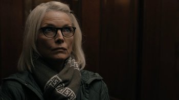 Movie still from “The Wizard of Lies” (2017), directed by Barry Levinson – An older woman wearing glasses and holding a scarf; Close Up shot, Over the shoulder angle