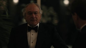 Movie still from “The Wizard of Lies” (2017), directed by Barry Levinson – An older man in a tuxedo with a bow tie; Close Up shot, Over the shoulder angle