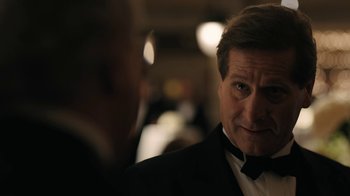 Movie still from “The Wizard of Lies” (2017), directed by Barry Levinson – A person wearing a suit and tie; Close Up shot, Over the shoulder angle