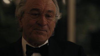 Movie still from “The Wizard of Lies” (2017), directed by Barry Levinson – An older man in a suit and bow tie; Close Up shot, Over the shoulder angle