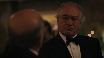 Movie still from “The Wizard of Lies” (2017), directed by Barry Levinson – An older man in a tuxedo looking at another older man; Close Up shot, Over the shoulder angle