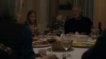Movie still from “The Wizard of Lies” (2017), directed by Barry Levinson – A group of people sitting around a table eating food; Medium shot, Over the shoulder angle