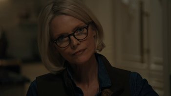 Movie still from “The Wizard of Lies” (2017), directed by Barry Levinson – A person wearing glasses and a jacket; Close Up shot, Over the shoulder angle