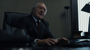 Movie still from “The Wizard of Lies” (2017), directed by Barry Levinson – An older man sitting at a computer in a room; Close Up shot, Over the shoulder angle
