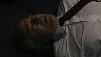 Movie still from “The Wizard of Lies” (2017), directed by Barry Levinson – An older man wearing a white dress shirt and a red tie; Close Up shot, Overhead angle