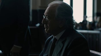 Movie still from “The Wizard of Lies” (2017), directed by Barry Levinson – An older man wearing a suit and tie; Close Up shot, Over the shoulder angle