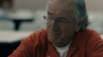 Movie still from “The Wizard of Lies” (2017), directed by Barry Levinson – An older man wearing glasses and an orange jacket; Close Up shot, Over the shoulder angle