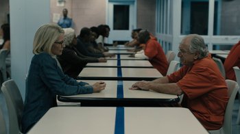Movie still from “The Wizard of Lies” (2017), directed by Barry Levinson – A group of people sitting at a long table; Medium shot, Over the shoulder angle