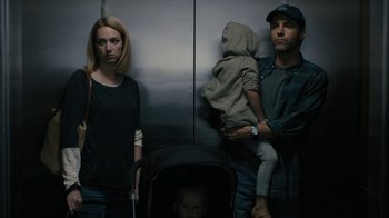 Movie still from “The Wizard of Lies” (2017), directed by Barry Levinson – A man and a woman and a baby in a stroller; Medium shot, Low angle