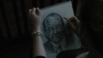 Movie still from “The Wizard of Lies” (2017), directed by Barry Levinson – A person is drawing a picture of an old man; Extreme Close Up shot, High angle