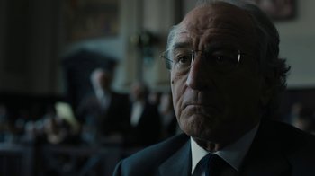 Movie still from “The Wizard of Lies” (2017), directed by Barry Levinson – An older man in a suit and tie looking at the camera; Close Up shot, Low angle