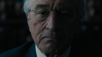Movie still from “The Wizard of Lies” (2017), directed by Barry Levinson – An older man wearing glasses and wearing a suit; Close Up shot, Over the shoulder angle