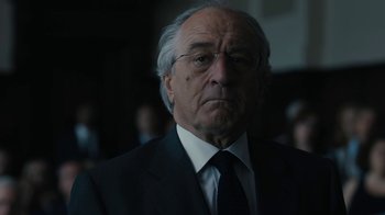 Movie still from “The Wizard of Lies” (2017), directed by Barry Levinson – An older man wearing a suit and tie; Close Up shot, Over the shoulder angle