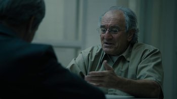 Movie still from “The Wizard of Lies” (2017), directed by Barry Levinson – An older man talking to a younger man in front of a table; Close Up shot, Over the shoulder angle