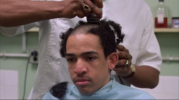 Movie still from “Full Metal Jacket” (1987), directed by Stanley Kubrick – A man getting his hair cut by a barber; Close Up shot, Low angle