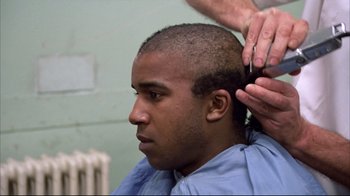 Movie still from “Full Metal Jacket” (1987), directed by Stanley Kubrick – A man getting his head shaved in a barber shop; Close Up shot, Over the shoulder angle