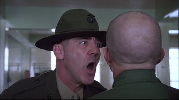 Movie still from “Full Metal Jacket” (1987), directed by Stanley Kubrick – A man in a hat and a uniform talking to another man; Close Up shot, Low angle
