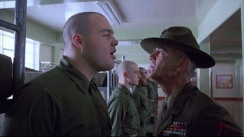 Movie still from “Full Metal Jacket” (1987), directed by Stanley Kubrick – A group of men standing next to each other in uniform; Medium shot, Low angle