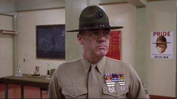 Movie still from “Full Metal Jacket” (1987), directed by Stanley Kubrick – A man in a uniform and a hat is looking at the camera; Medium shot, Low angle