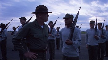 Movie still from “Full Metal Jacket” (1987), directed by Stanley Kubrick – A group of men standing next to each other holding guns; Medium shot, Low angle