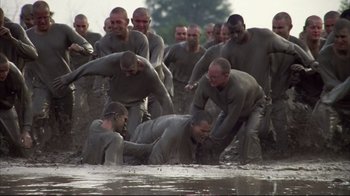 Movie still from “Full Metal Jacket” (1987), directed by Stanley Kubrick – A group of men in the mud playing tug of war in the water; Wide shot, High angle