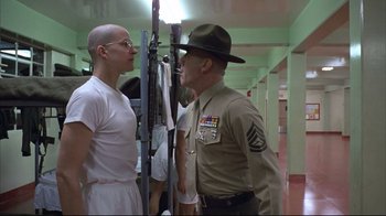 Movie still from “Full Metal Jacket” (1987), directed by Stanley Kubrick – A man in a uniform talking to another man; Medium shot, Over the shoulder angle