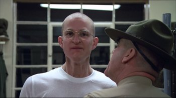 Movie still from “Full Metal Jacket” (1987), directed by Stanley Kubrick – A man with a shaved head and a man in a uniform; Close Up shot, Over the shoulder angle