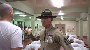 Movie still from “Full Metal Jacket” (1987), directed by Stanley Kubrick – A man in uniform holding a hot dog in his hand; Medium shot, Low angle