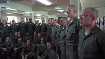 Movie still from “Full Metal Jacket” (1987), directed by Stanley Kubrick – A group of men standing in a room together; Wide shot, High angle