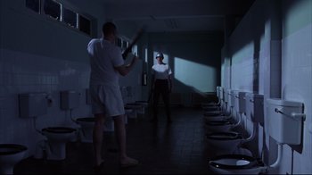 Movie still from “Full Metal Jacket” (1987), directed by Stanley Kubrick – A man and a woman are standing in a bathroom; Wide shot, High angle