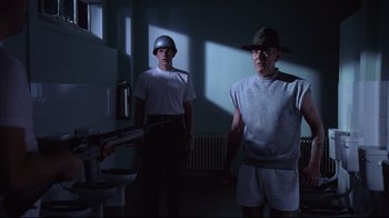Movie still from “Full Metal Jacket” (1987), directed by Stanley Kubrick – Two men are standing in a room holding guns; Medium shot, Low angle