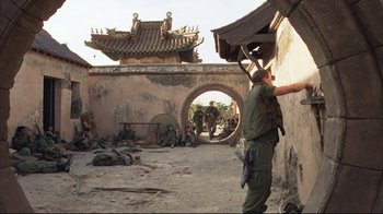 Movie still from “Full Metal Jacket” (1987), directed by Stanley Kubrick – A group of soldiers are sitting and standing in a courtyard; Wide shot, Over the shoulder angle