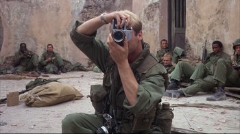 Movie still from “Full Metal Jacket” (1987), directed by Stanley Kubrick – A man taking a picture of himself with a camera; Medium shot, High angle