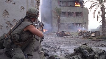 Movie still from “Full Metal Jacket” (1987), directed by Stanley Kubrick – A man in fatigues is holding a gun; Wide shot, Over the shoulder angle