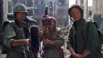 Movie still from “Full Metal Jacket” (1987), directed by Stanley Kubrick – A group of men standing next to each other in the street; Medium shot, Low angle