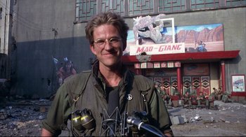Movie still from “Full Metal Jacket” (1987), directed by Stanley Kubrick – A man with glasses is standing in front of a building; Close Up shot, Low angle